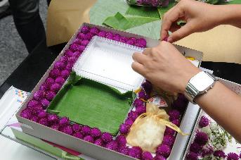 กล่องกระดาษ ด้านในวางกล่องพลาสติกใสและใบตองสำหรับใส่ขนมไทย
