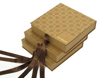 กล่องของขวัญสีทองสวยหรู ด้านนอกพิมพ์ลายสีน้ำตาล ติดริบบิ้นสีน้ำตาลทอง สำหรับผูกปิดฝากล่อง