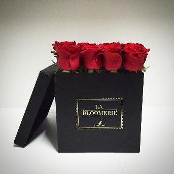 กล่องกระดาษสีดำ โลโก้ปั๊มฟอยล์สีเงินเงา บรรจุดอกกุหลาบสีแดงสด สวยงามคลาสสิค