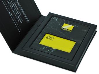 กล่องด้านใน เคลือบ Spot UV โลโก้ Nikon  ไดคัทช่องวางอคิริค หนา  3 มม.  ด้านล่างช่องวางอคิริคพิมพ์สีเหลืองและสีดำ
