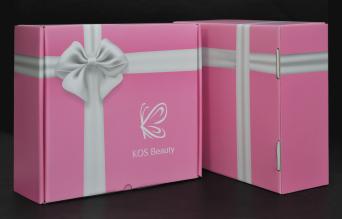 กล่องเครื่องสำอาง โดย KOS Beauty กล่องสีชมพู ดีไซน์ภาพริบบิ้นผูกโบว์สีขาวคาดรอบกล่อง